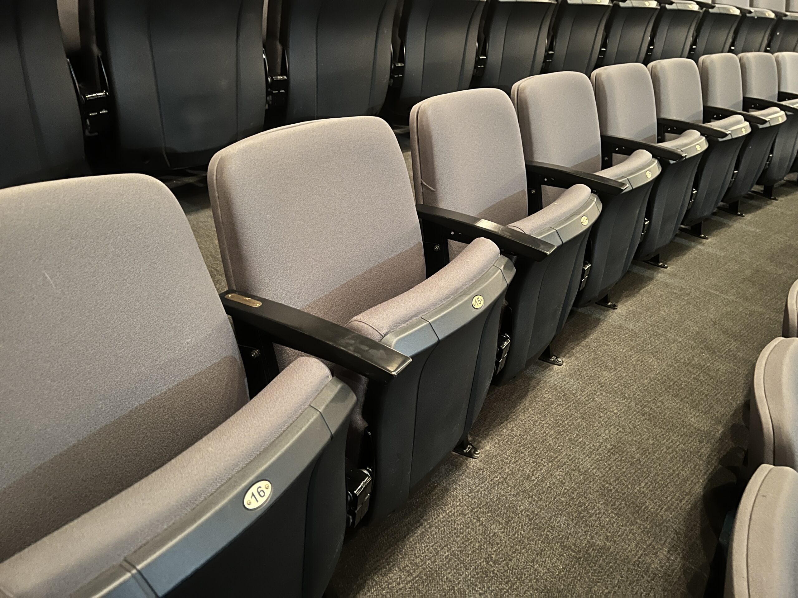 A photograph of light grey audience seats in the Maclab Theatre.